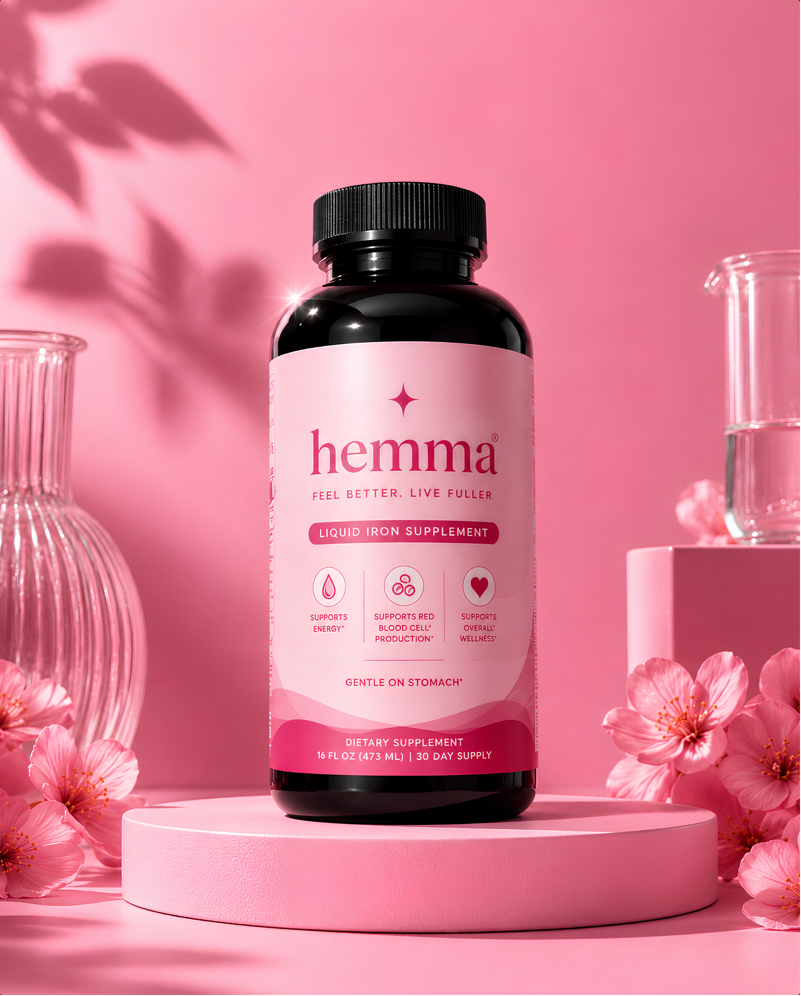hemma liquid iron supplement, 16 fl oz bottle on a pink podium with cherry blossoms