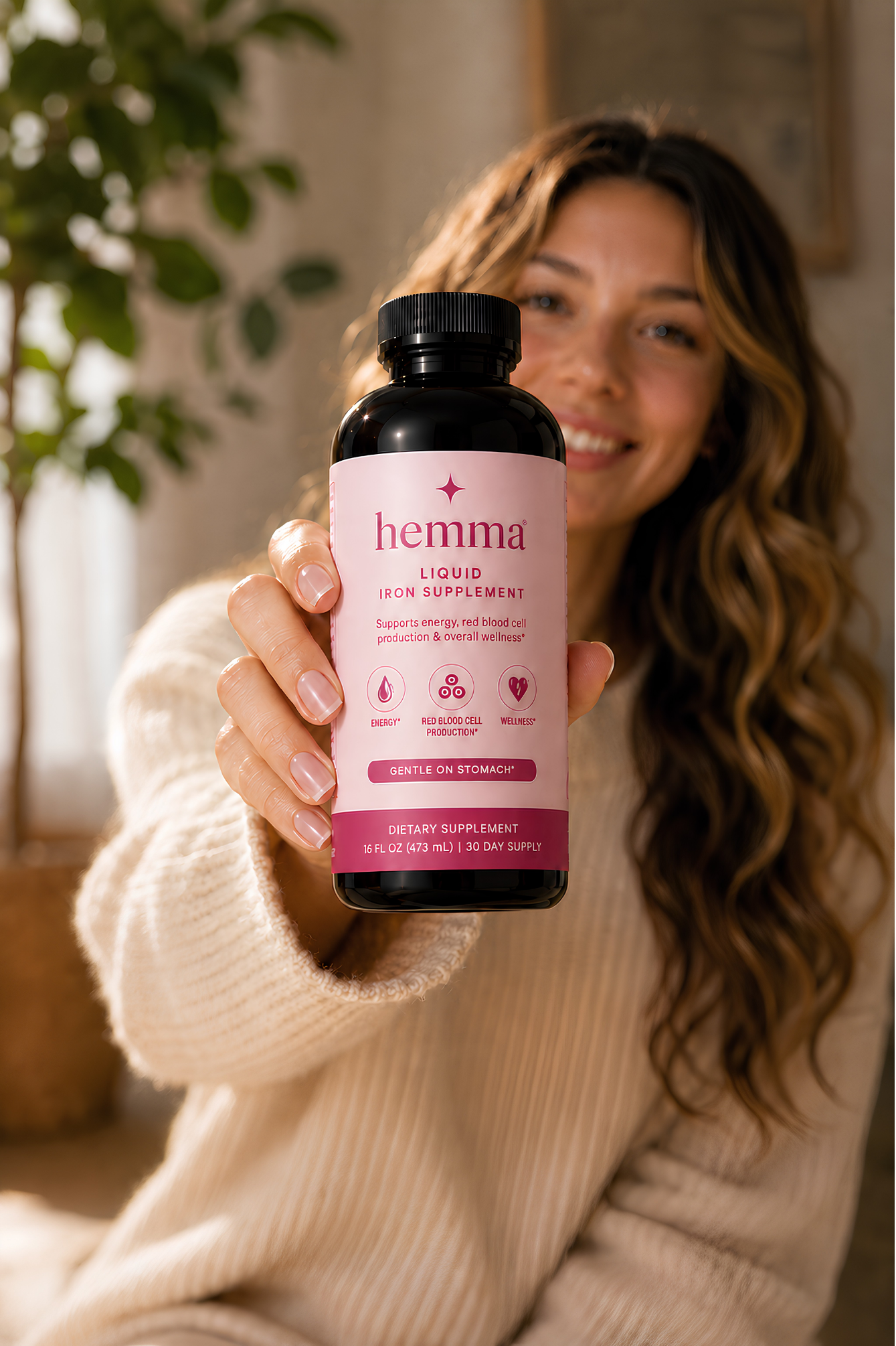 Woman holding a bottle of hemma liquid iron supplement at home